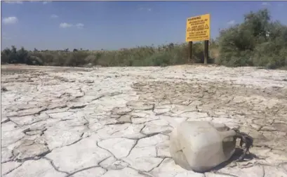  ?? IMPERIAL VALLEY PRESS FILE PHOTO ?? An empty plastic gallon lays on the chemically polluted bank of the New River in Calexico.