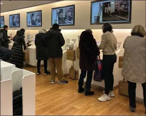  ?? (AP/Anne D’Innocenzio) ?? Shoppers at a Uniqlo store in New York use self-checkout earlier this month.