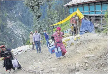  ?? REUTERS ?? A local health worker carries boxes containing Covishield vaccine at remote Malana village in Kullu district on Friday.