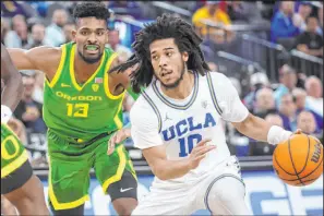  ?? Chase Stevens The Associated Press ?? UCLA point guard Tyger Campbell drives around Oregon forward Quincy Guerrier in the Bruins’ 75-56 win Friday at T-mobile Arena.
