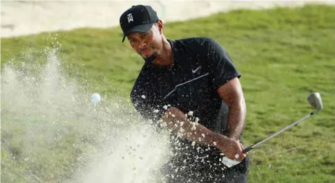  ?? — AFP ?? NASSAU: Tiger Woods of the United States hits a shot from a greenside bunker on the 14th hole during round one of the Hero World Challenge at Albany, The Bahamas on Thursday in Nassau, Bahamas.