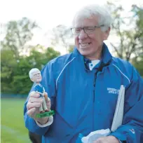  ?? SPECIAL TO THE MORNING CALL MATT SMITH/ ?? Southern Lehigh head coach Brian Neefe holds a bobblehead with his likeness given to him by his current team during a celebratio­n following his 1,000th game for the softball program in 2017. Neefe retired this week after 52 seasons in charge of the Spartans softball program.