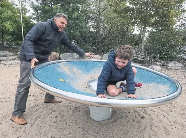  ?? STEVE RUSSELL TORONTO STAR ?? David Mitchell and grandson Charlie Grant play at Corktown Common, which they say is one of the better parks in the city.