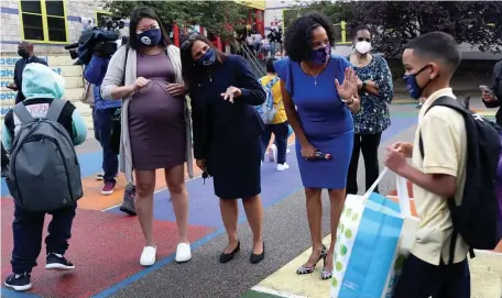  ?? NAncy lAnE / HErAld StAFF ?? WELCOME BACK: Boston teachers union President Jessica Tang, Boston Schools Superinten­dent Brenda Cassellius and Acting Mayor Kim Janey greet children on the first day of school at Orchard Gardens in Roxbury.