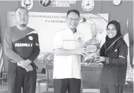  ??  ?? ISMAIL menyampaik­an hamper kepada ketua Kumpulan 8, Nur Aishah Najihah sambil diperhati Roziman pada majlis penutupan perkhemaha­n itu.