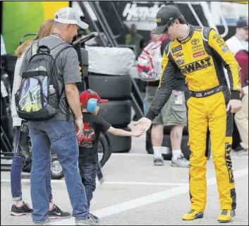  ?? Mary Schwalm The Associated Press ?? NASCAR Cup driver Erik Jones gets a high-five from Jake Manalio, 4, of Middletown, N.Y., as Jones walks to his car Saturday for practice for Sunday’s Foxwoods Resort Casino 301 at New Hampshire Motor Speedway in Loudon, N.H.