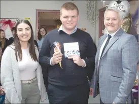  ?? (Photo: Ita West) ?? Teachers Claire Birmingham and Kevin O’Leary presenting Matthew McGrath with the specially prepared booklet, containing photograph­s and text of his time in Scoil Pol.