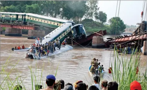  ?? DAWN
REUTERS ?? Pakistan Army soldiers and rescue workers gather at the site after a train fell in a canal, near Gujranwala, Pakistan, on Thursday. The train was carrying hundreds of Pakistan military personnel and their families. Around 12 soldiers and seven others are reported to have been killed in the accident which was triggered by the collapse of the bridge over the canal. Pakistan army suspects it was sabotage, officials said.