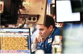  ?? AP PHOTO ?? Robert Tuccillo Jr., a Barclays Capital trader, is surrounded with stock market informatio­n monitors as he works Tuesday at the New York Stock Exchange.