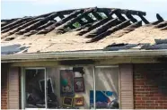  ?? STAFF PHOTO BY DOUG STRICKLAND ?? Artwork hangs on the walls beneath the burned roof of a home at 604 Bitsy Lane in Red Bank on Friday after an overnight house fire left one man dead.