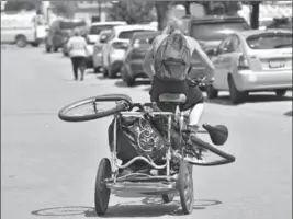  ??  ?? A MAN LEAVES THE WESLEY CENTRE WITH SCRAP PACKED ONTO HIS BIKE’S TRAILER.