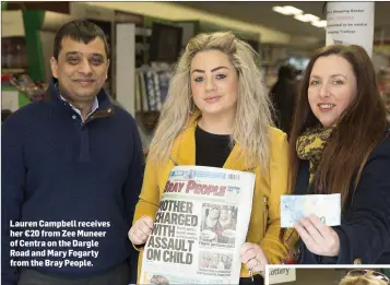  ??  ?? Lauren Campbell receives her €20 from Zee Muneer of Centra on the Dargle Road and Mary Fogarty from the Bray People.