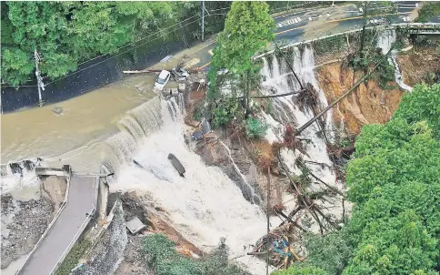  ??  ?? A collapsed road is seen following torrential rain caused by typhoon Lan in Kishiwada. — Reuters photo