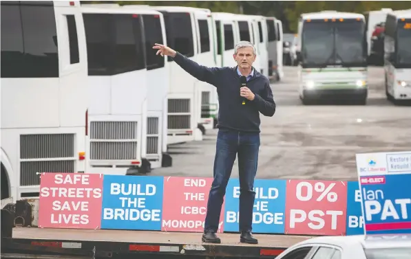  ?? THE CANADIAN PRESS/DARRYL DYCK ?? Liberal Leader Andrew Wilkinson speaks during a drive-in car rally campaign stop at a tour bus operator in Delta. Wilkinson is calling for bridge financing for businesses in the tourist industry that have been battered by the impact of the COVID-19 pandemic.