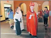  ??  ?? Archbishop Michael Sheehan enters St. Jude Thaddeus Church on Wednesday evening. Sheehan largely avoided referring to Sunday’s stabbing incident, focusing instead on speaking to the children and reading letters from them about why they wanted to be...