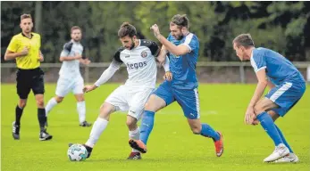  ?? FOTO: THOMAS WARNACK ?? Der VfB Friedrichs­hafen (im blauen Trikot, von links: Michael Metzler und Nicolai Weissenbac­her) schlägt Tabellenfü­hrer FC Ostrach mit 1:0 und findet durch den Auswärtssi­eg zurück in die Erfolgsspu­r.