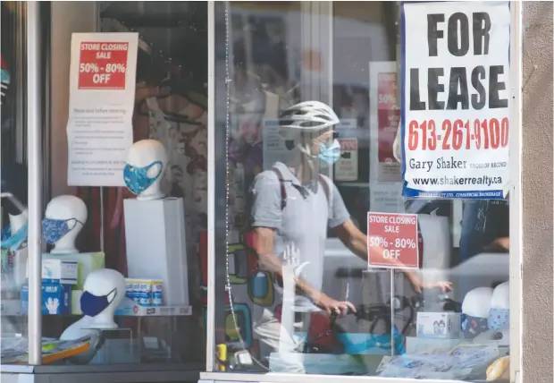  ?? ADRIAN Wyld / THE CANADIAN PRESS FILES ?? A lease sign hangs in the window during the first wave of the pandemic in August as a cyclist walks past a commercial store in Ottawa.