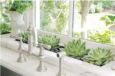  ?? TRIA GIOVAN/MEREDITH VIA THE ASSOCIATED PRESS ?? Succulents in a kitchen window planter. Typically a good place for plants, a kitchen offers easy access to water and higher humidity than other rooms. Here, light-loving sedums are tucked into a custom granite well.