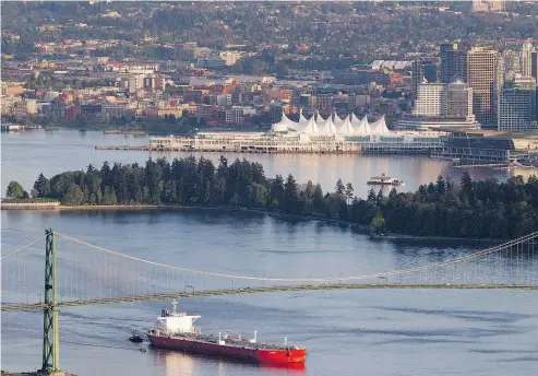  ?? JONATHAN HAYWARD / THE CANADIAN PRESS FILES ?? An oil tanker goes under Lions Gate Bridge in Vancouver. Washington state’s opposition to the Trans Mountain pipeline expansion is ironic given the state is a far bigger user of oil tankers than B.C., Tristin Hopper writes.