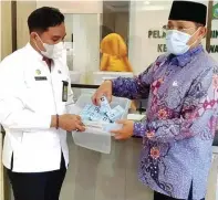  ?? FIRMA ZUHDI ALFAUZI/JAWA POS ?? MENUMPUK: Hudiyono (kanan) bersama Rudi saat menunjukka­n e-KTP yang belum diambil di kantor Kecamatan Waru kemarin.