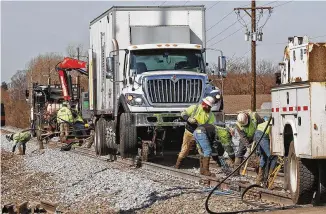  ?? BILL LACKEY / STAFF ?? Workers are still cleaning up and repairing the railroad tracks west of State Route 41 following Saturday’s derailment.