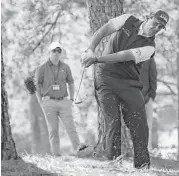  ?? Jason Getz / TNS ?? Phil Mickelson hits out of the woods off of the first fairway, which served as an omen. He also found shrubbery and water during his 7-over 79 Friday.