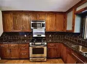  ??  ?? The updated kitchen offers custom cabinetry and granite countertop­s.