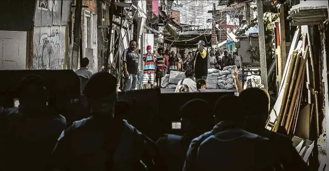  ??  ?? Policiais diante de moradores da favela do Moinho, no centro de São Paulo, depois de ação da PM que resultou na morte de um rapaz de 19 anos na manhã desta terça-feira (27)