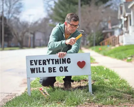  ??  ?? Dave Heinzel installs a handmade sign in front of a home in Springfiel­d, Ill.