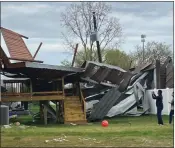  ?? PHOTOS COURTESY OF WASHINGTON TOWNSHIP FIRE DEPARTMENT ?? Residents take photos of the damage caused by the carport that was pushed into a home outside Stony Creek Apartments, near Van Dyke Avenue and 27Mile Road in Washington Township.