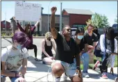  ?? BEA AHBECK/NEWS-SENTINEL ?? Dailsy Williams, of Stockton, center, kneels with others for 8 minutes and 46 seconds, the length of time a Minneapoli­s police officer kneeled on George Floyd’s neck, during a Saturday protest for human rights at Kettleman Lane and Lower Sacramento Road in Lodi.