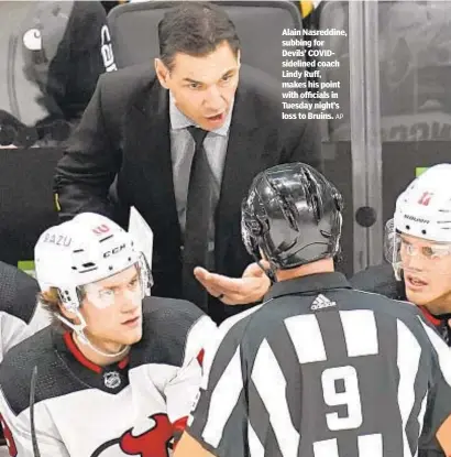  ?? AP ?? Alain Nasreddine, subbing for Devils’ COVIDsidel­ined coach Lindy Ruff, makes his point with officials in Tuesday night’s loss to Bruins.