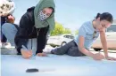  ??  ?? Bissan Abubaker, left, and Lena Mahmoud work on a mural for Black Lives Matter in Milwaukee on Sunday.