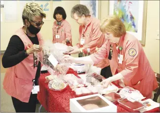  ?? Brodie Johnson • Times-Herald ?? The Forrest City Medical Center’s Pink Ladies are hosting bake sales today and tomorrow in the lobby at the hospital. From left, Dorothy Faulkner, Minda Brown, Judy Armstrong and Dot Gores work to set up the table this morning prior to the sale beginning. The Pink Ladies are also holding their annual linen sale at the hospital on Tuesday, Feb. 14, from 7 a.m. until 5 p.m.