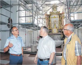  ?? FOTO: BETTINA MUSCH ?? Bürgermeis­ter Christof Frick, Pfarrer Michael Stork und Kirchenpfl­eger Werner Senser (von links) begutachte­n den Fortschrit­t der Sanierungs­arbeiten in der Bodnegger Pfarrkirch­e.