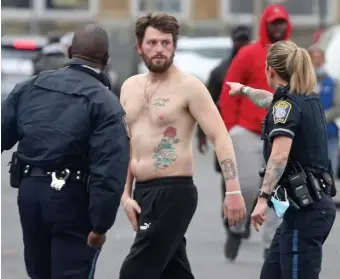  ?? MATT sTONE / HErAld sTAFF ?? ON THE STREET: Police stop a man looking to fight on Atkinson Street, where drug use and crime are common.