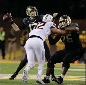  ?? AP PHOTO ?? Baylor quarterbac­k Seth Russell, back, throws a touchdown pass as teammate Mo Porter, right, blocks Oklahoma State defensive end Cole Waltersche­id.