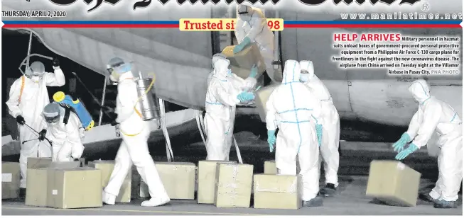  ?? PNA PHOTO ?? HELP ARRIVES
Military personnel in hazmat suits unload boxes of government-procured personal protective equipment from a Philippine Air Force C-130 cargo plane for frontliner­s in the fight against the new coronaviru­s disease. The airplane from China arrived on Tuesday night at the Villamor Airbase in Pasay City.