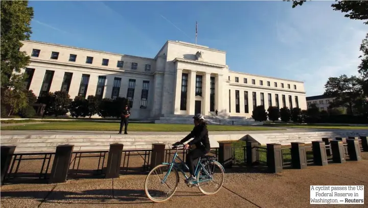  ?? — Reuters ?? A cyclist passes the US Federal Reserve in Washington.