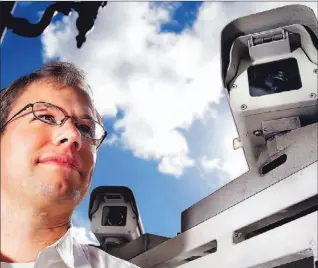  ?? JEFF CHIU/ AP PHOTO ?? Jay Benson, a vice-president of Tele Atlas, with van-mounted image-gathering cameras that provide the images and content that online map users are demanding. Traffic to map websites is growing fast.