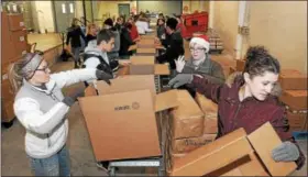  ?? GENE WALSH — DIGITAL FIRST MEDIA ?? Volunteers and employees pack boxes of food items for area families during The Mercury’s annual Operation Holiday in Pottstown.