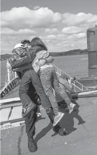  ??  ?? Master Seaman Patrick Beaton gets a hug from his children Xavier, 6, and Ariana, 9, after stepping off of HMCS Chicoutimi at CFB Esquimalt.