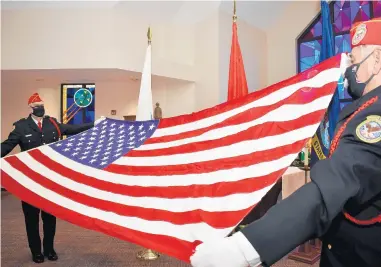  ?? MARY COMPTON/DAILY SOUTHTOWN PHOTOS ?? Ken Witowski, of Orland Park, holds one side of the American flag while Tony Mehok, of Homer Glen, has the other during the 13 Folds of the Flag, presented by members of the Abraham Lincoln National Cemetery Color Guard.