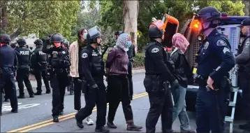  ?? DAVID ALLEN — STAFF ?? Police detain protesters near a transport vehicle on Friday at Pomona College in Claremont.