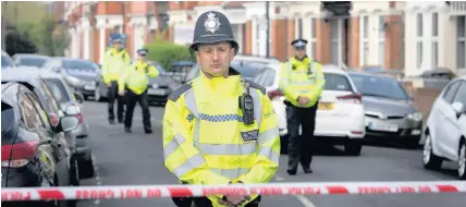  ??  ?? > Police in Harlesden Road, London, after a woman in her twenties was shot by police and four people arrested