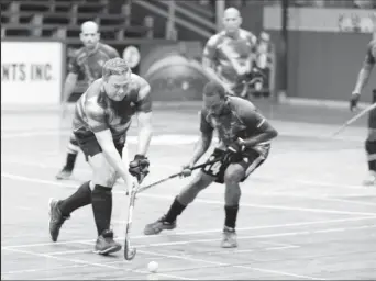  ?? ?? Former national captains Philip Fernandes (left) of 50 Not-Out and Devin Munroe of Guyana 40s battling for possession at the Cliff Anderson Sports Hall in the ExxonMobil National Indoor Championsh­ips.