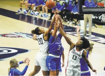  ?? David Butler II / USA TODAY ?? Olivia NelsonOdod­a ( 20) and Christyn Williams ( 13) sandwich Creighton’s Emma Ronsiek while battling for a rebound in the second half of No. 3 UConn’s 8047 win in Storrs, Conn.