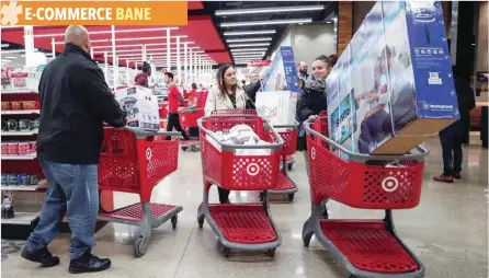  ?? — Reuters ?? Customers push their shopping carts after making a purchase at Target in Chicago, Illinois.