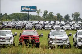  ?? JAKE MAY — THE FLINT JOURNAL VIA AP ?? Flint-built trucks are parked in a vacant field in September in Flint, Mich. The Chevrolet Silverados and GMC Sierra pickups built at Flint Assembly are waiting for semiconduc­tors.