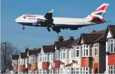  ?? AFP ?? A British Airways 747 passes over suburbia as it comes in to land at Heathrow airport in west London
